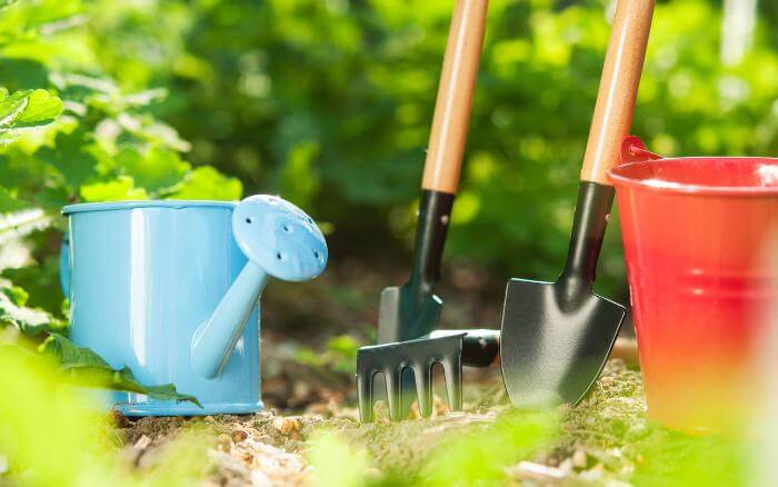 ferramentas-de-jardinagem-sobre-o-solo-pa-ancinho-e-regador